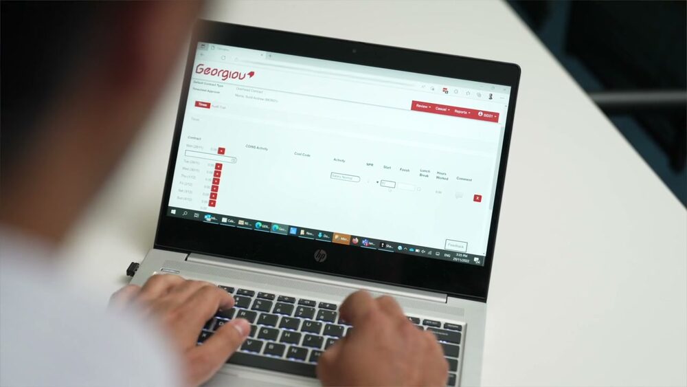 A Georgiou team member using their custom business software on a laptop